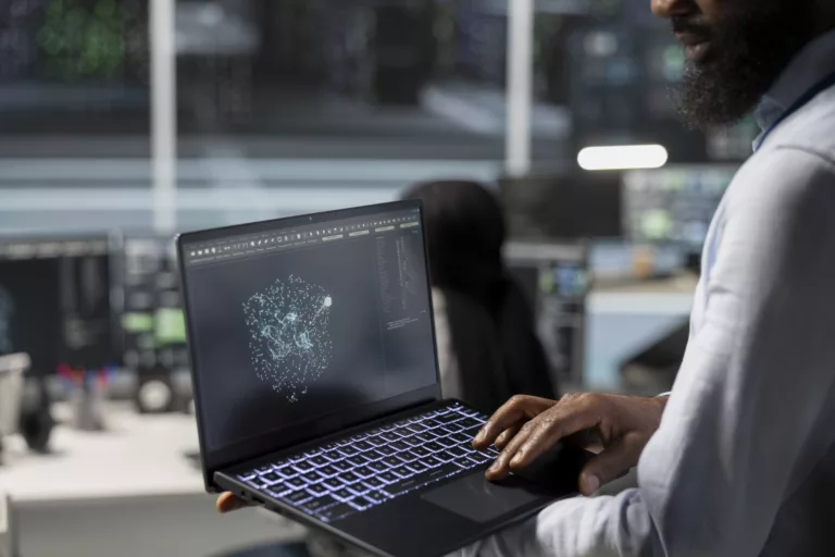 Close up of data center engineer using laptop to implement AI virtualization frameworks, improving resource allocation. Server hub worker does artificial intelligence predictive analysis on notebook
